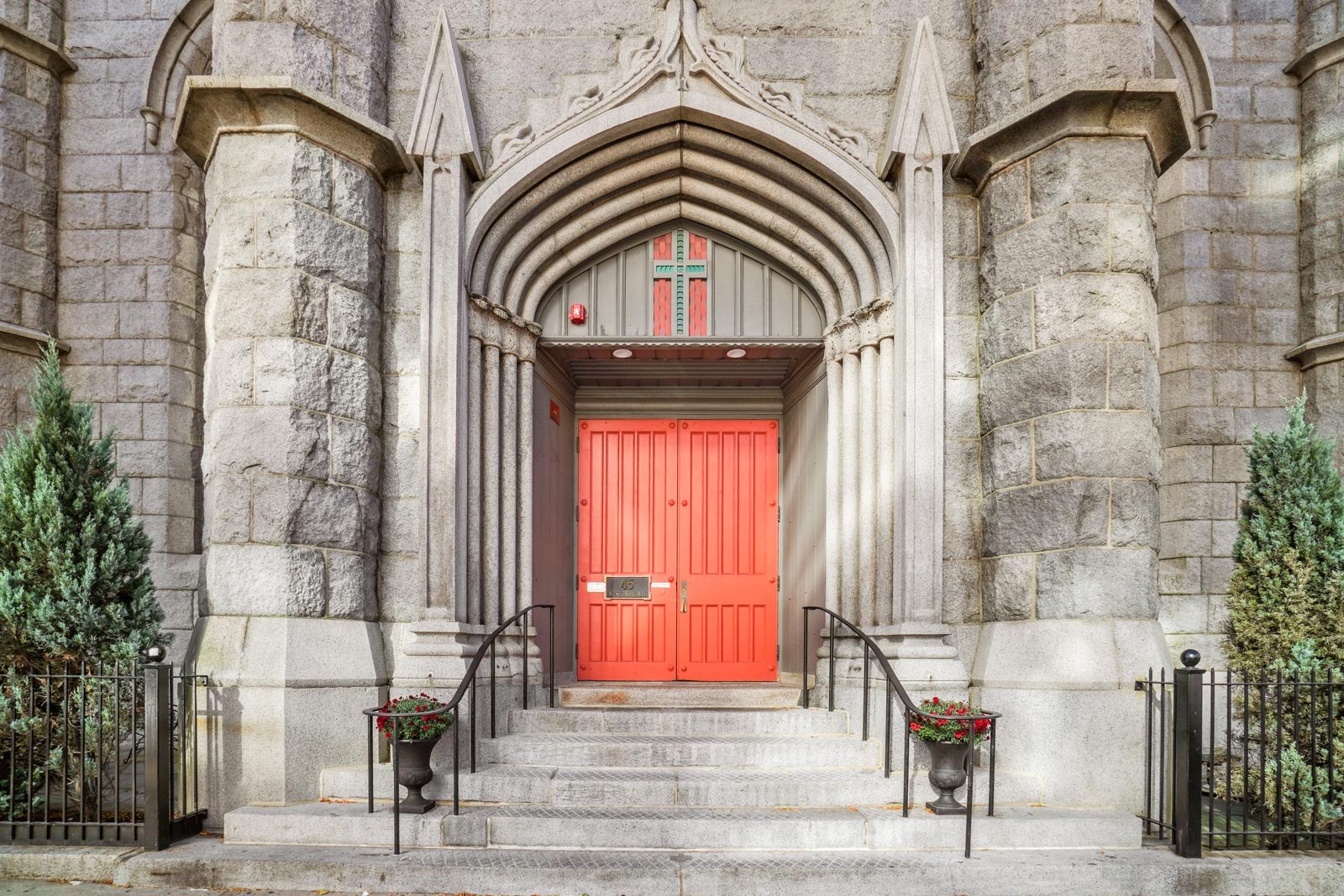 Church like facade with large red doors.