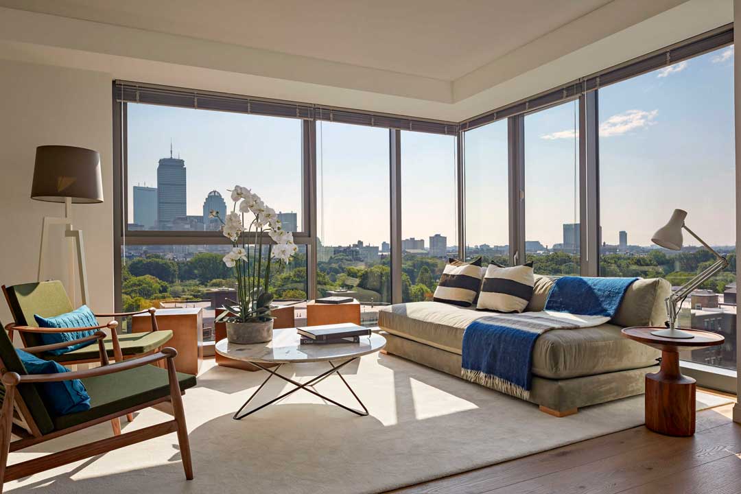 Open floor plan living room with large windows, hardwood floors, and skyline views.