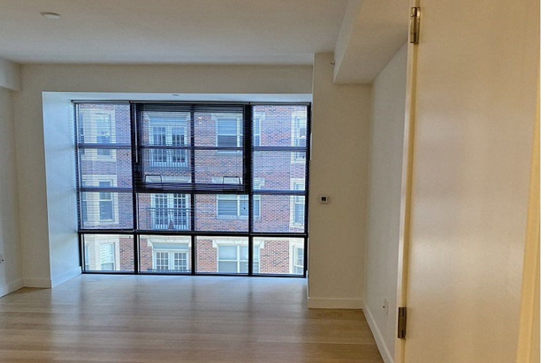 Apartment interior features a wall of windows.