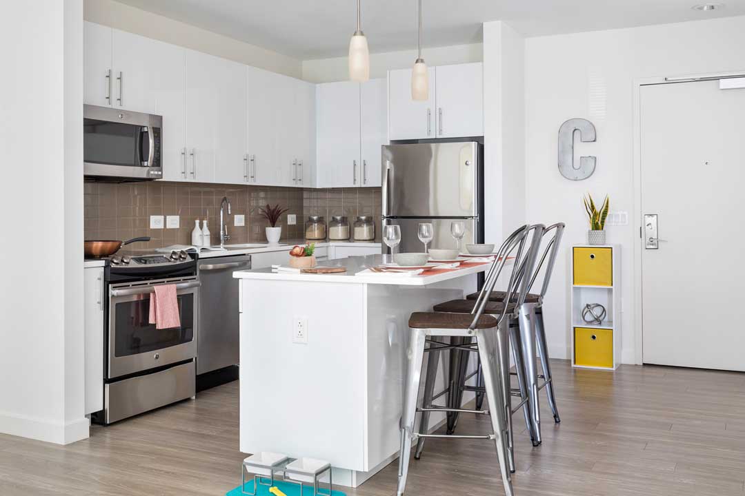 Modern kitchen with stainless appliances, island.