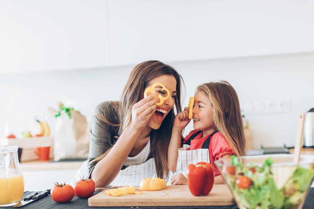 Mother and daughter happy at home cooking together