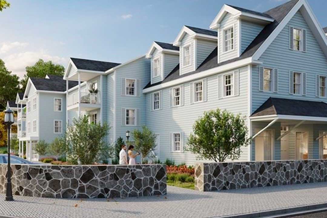 Rendering of exterior shows 3 story colonial architecture with nice stone wall and landscaping. Some units with balconies.