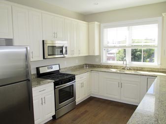 modern kitchen with white cabinets and stainless steel appliances at 375 Market Street