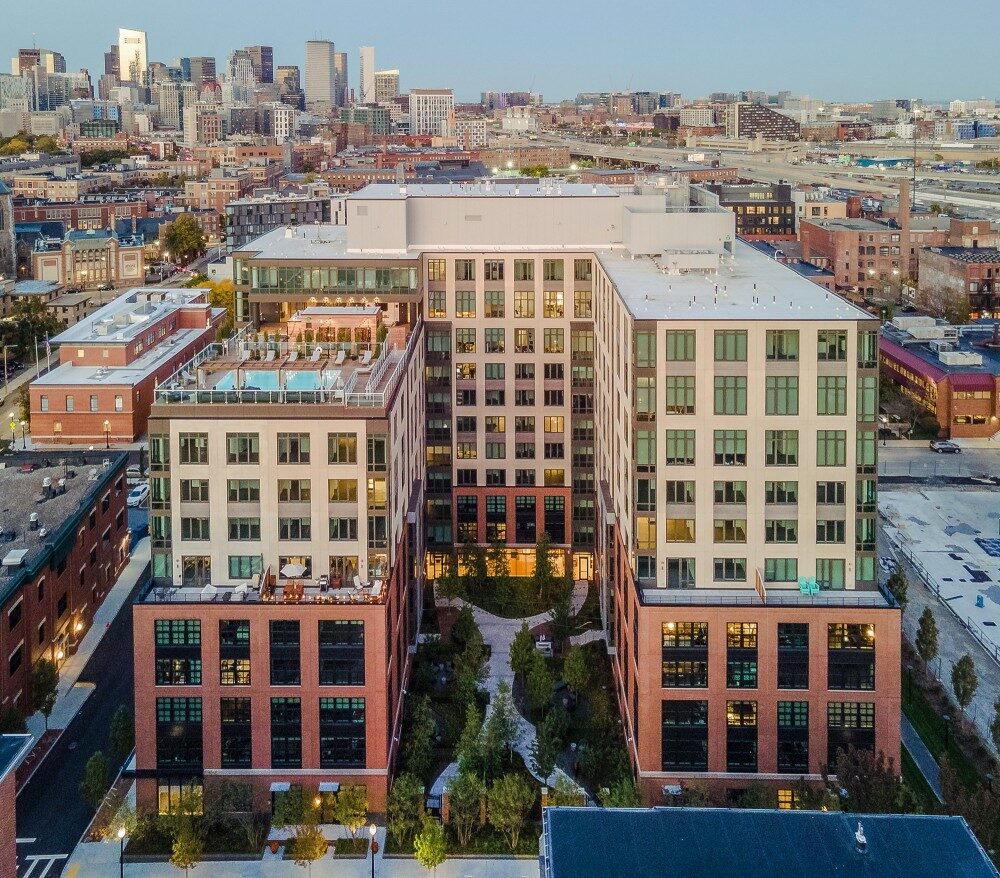 Bird's eye view of high rise building with landscaped inner courtyard and rooftop pool and public seating areas