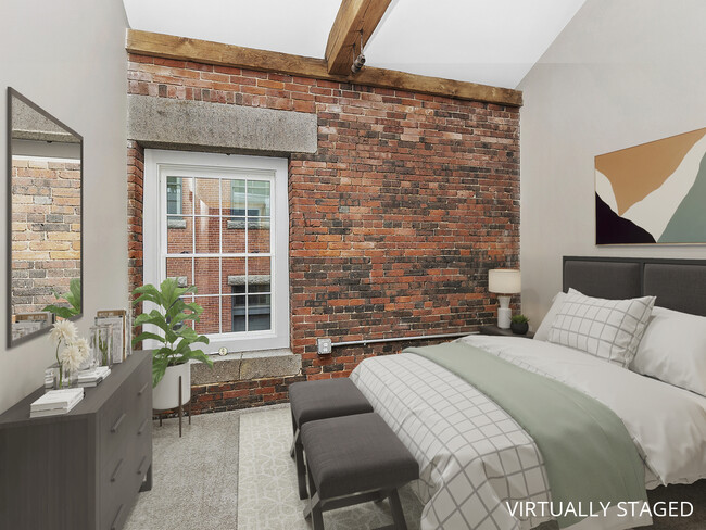 bedroom with window and exposed brick