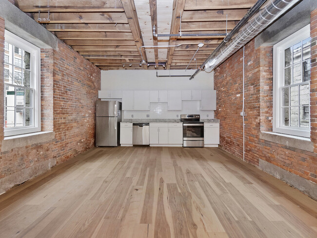 ropewlak kitchen and living area unfurnished with exposed brick