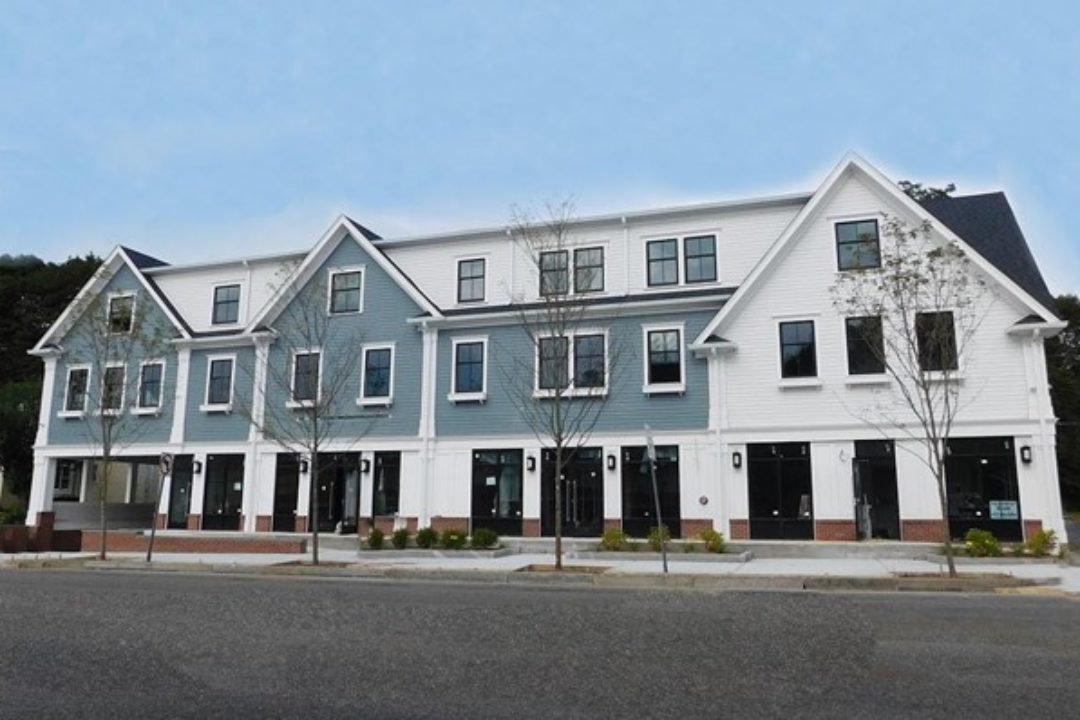 Three story building, colonial style, commercial space on first floor.
