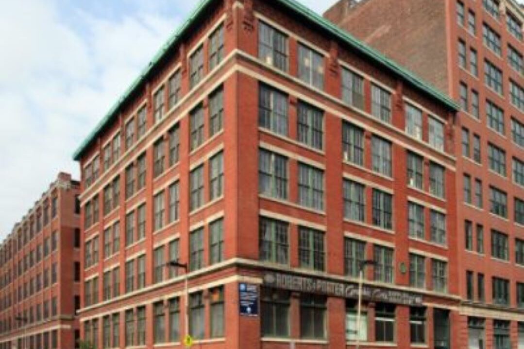 Five story brick building with lots of large windows.