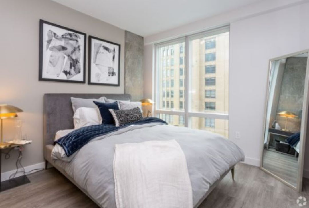 bedroom with luxury hard plank flooring, large closets with shelves.