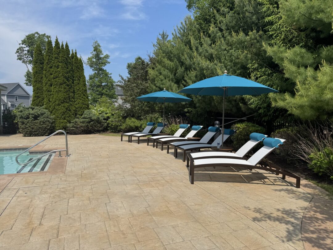 outdoor pool surrounded by sun loungers and umbrellas