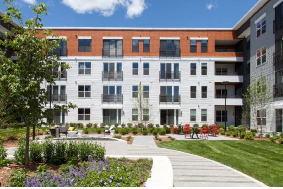 Four-story building that has landscaped courtyard with seating areas