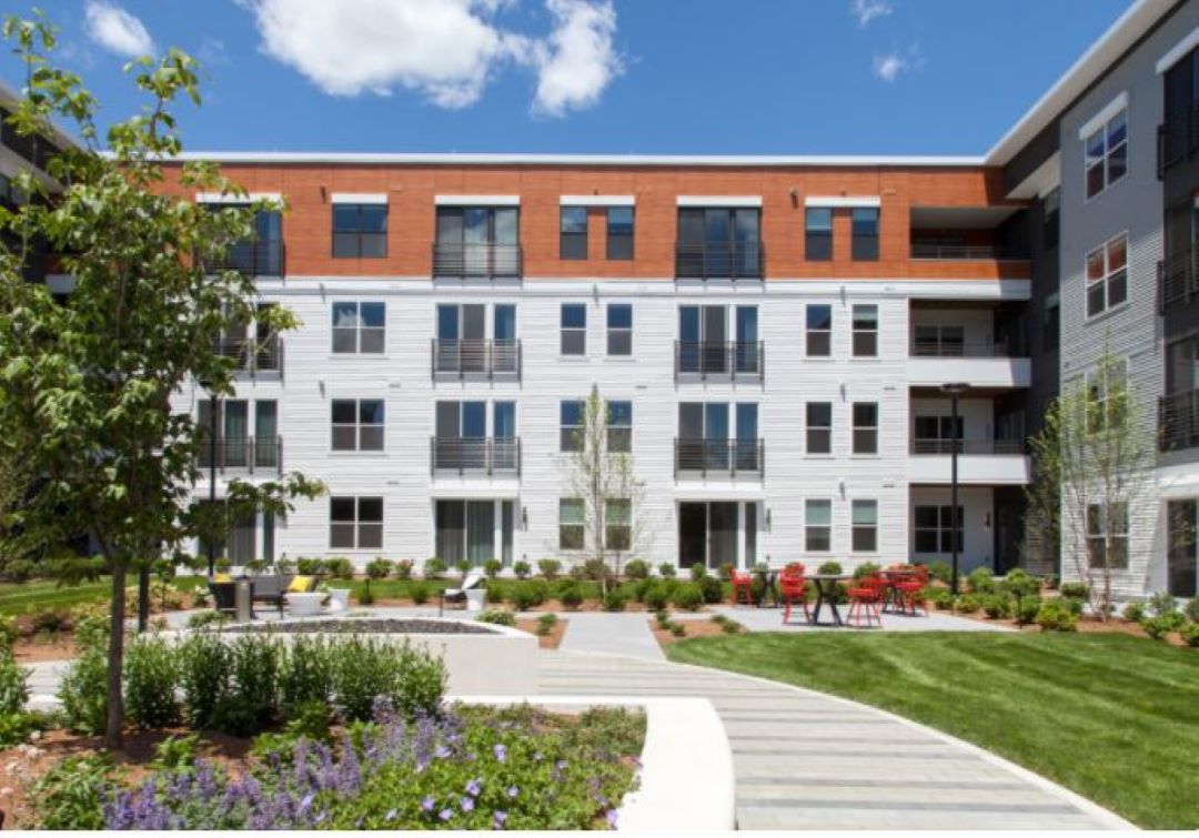 Four-story building that has landscaped courtyard with seating areas