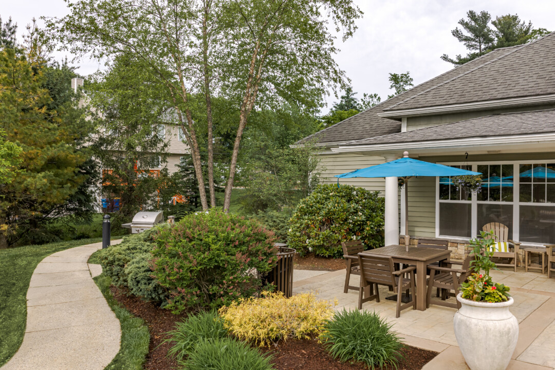 Community clubhouse overlooking the resort-style swimming pool with outdoor seating and landscaped grounds.