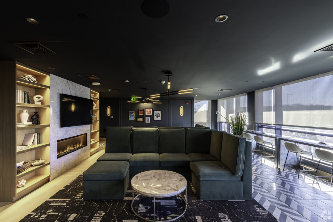 sitting area with large couch and tv/fireplace in center of the room and additional chairs/tables behind