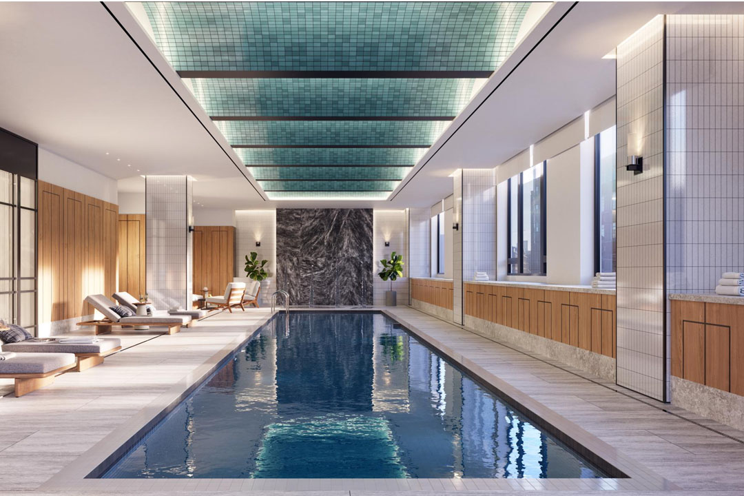 Beautiful spa-style indoor swimming pool with lounge chairs and windows.