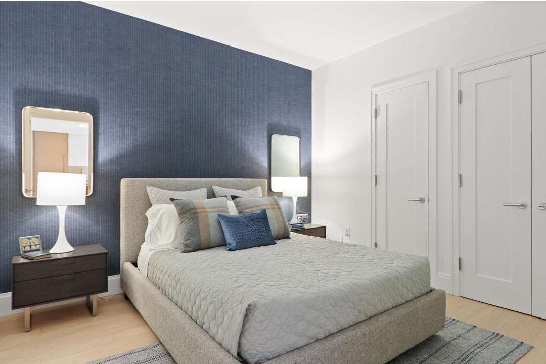 Bedroom with designer paint and wallpaper, large closets, luxury plank flooring.