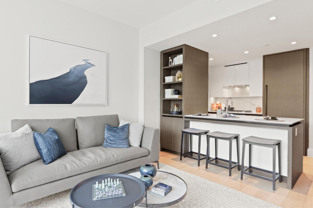 Kitchen island overlooks living space. Luxury plank flooring. Modern cabinetry.