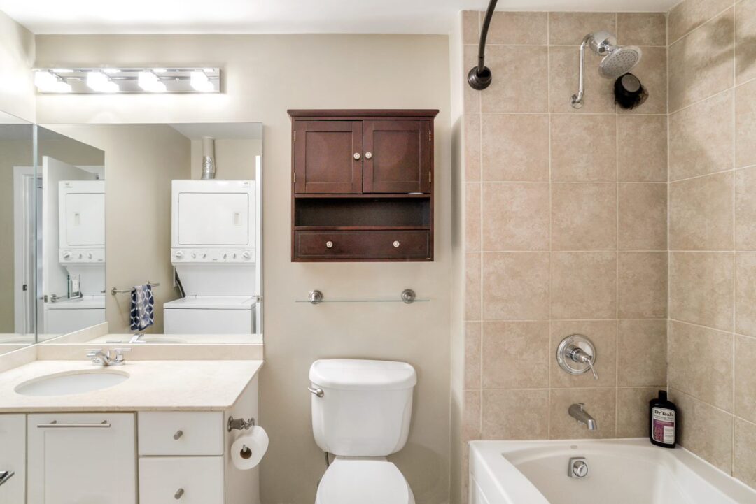 updated bathroom with vanity and modern lighting and titled shower/tub