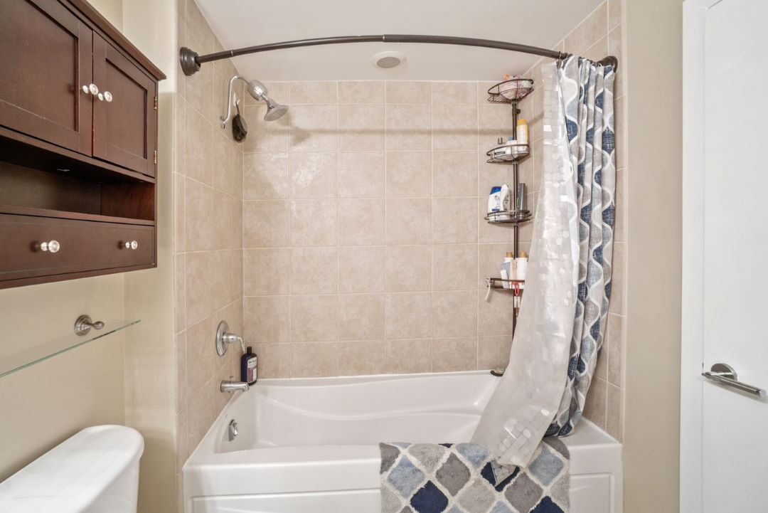 updated bathroom with beige tile tub/shower