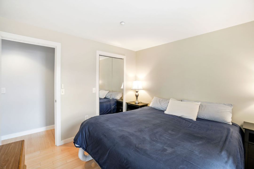 small beige bedroom with mirrored door closet