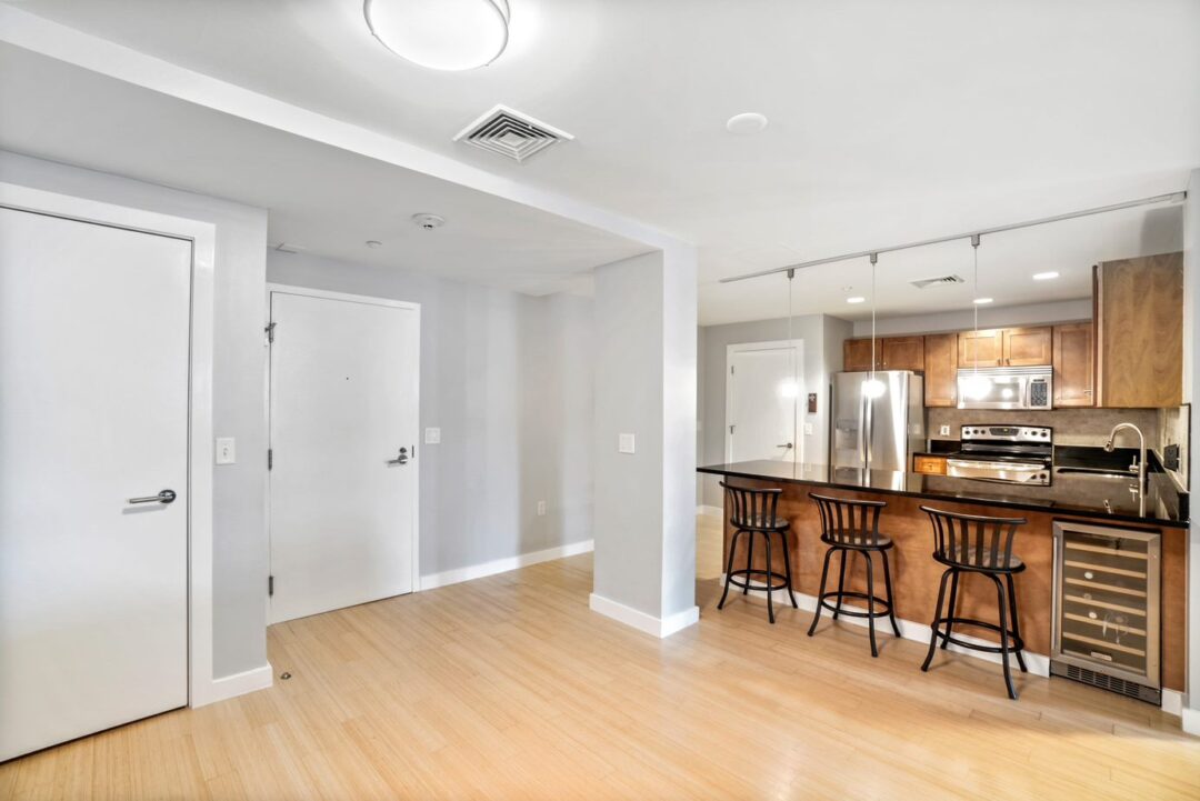 entryway open to kitchen with ceiling light and hardwood floors