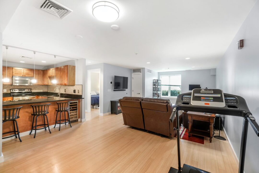 front entry of living room space with hard wood floors, recessed lighting open to kitchen