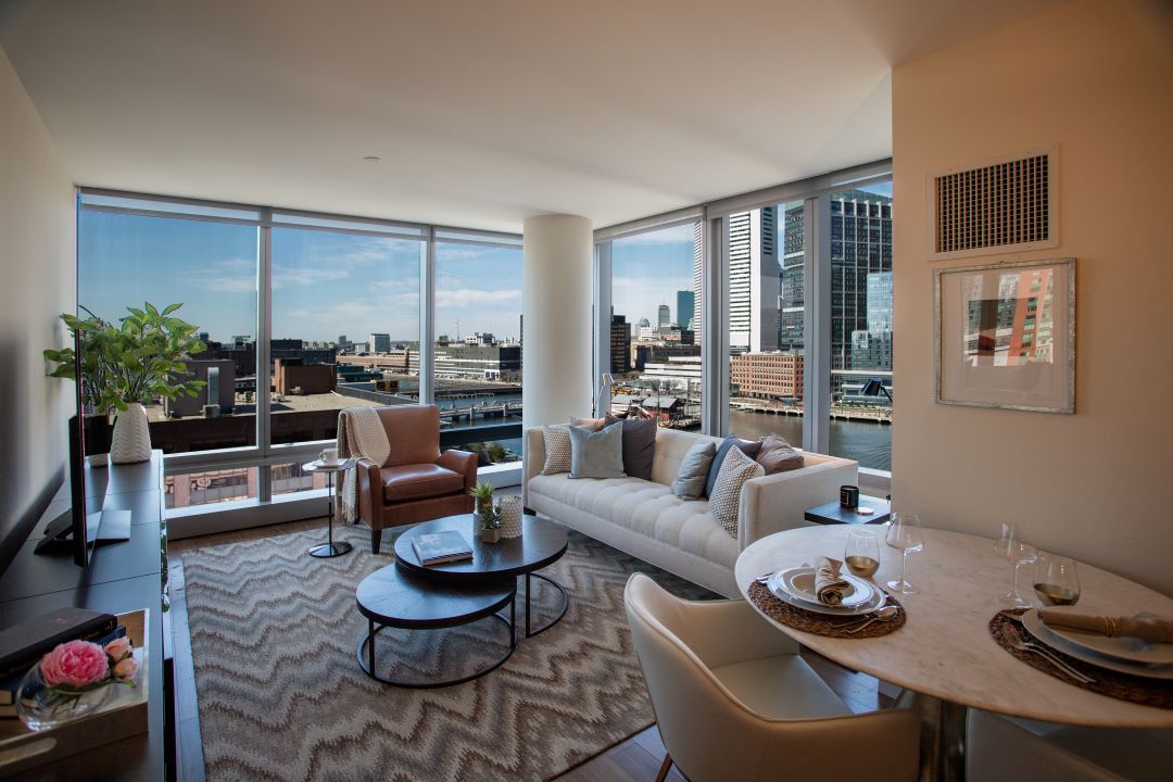 Striking and modern living space featuring large picture windows and city views