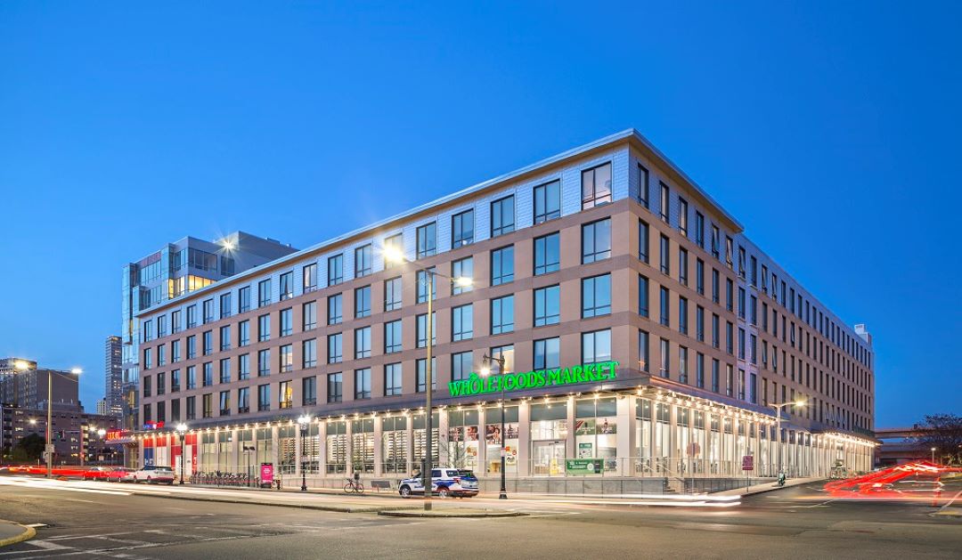 multi-story apartment building with commercial storefront on ground level