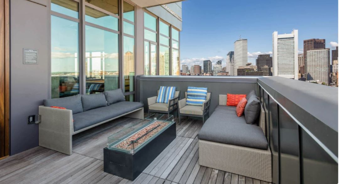 rooftop deck with comfortable seating, fire pit and city/skyline views