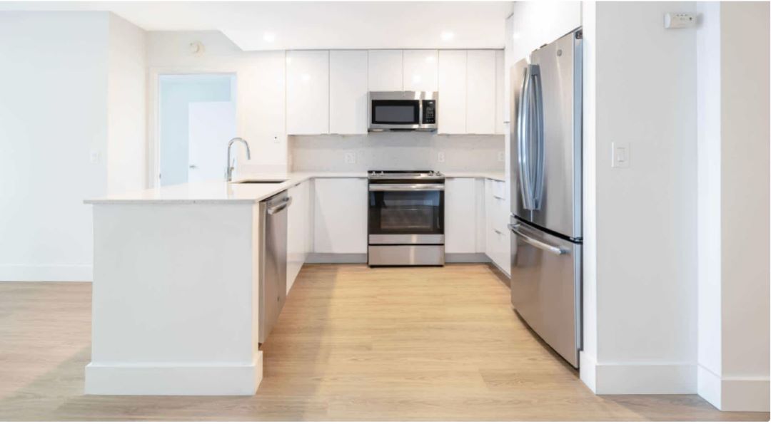 Modern kitchen with steel appliances, wood flooring and center island