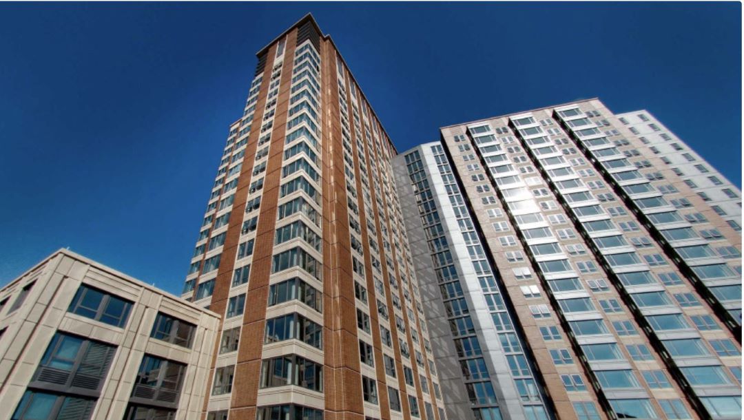 Multi-Story condo style building with brick and stone facade and lots of windows