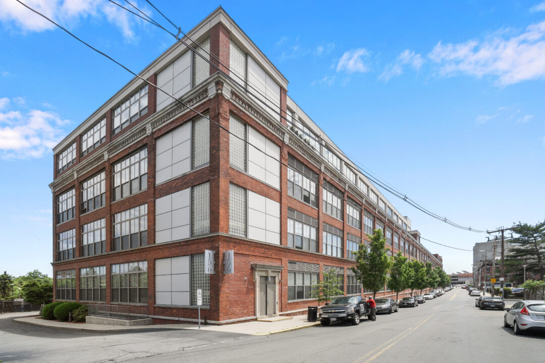 Multi Story condo style building with brick and stone facade and lots of windows