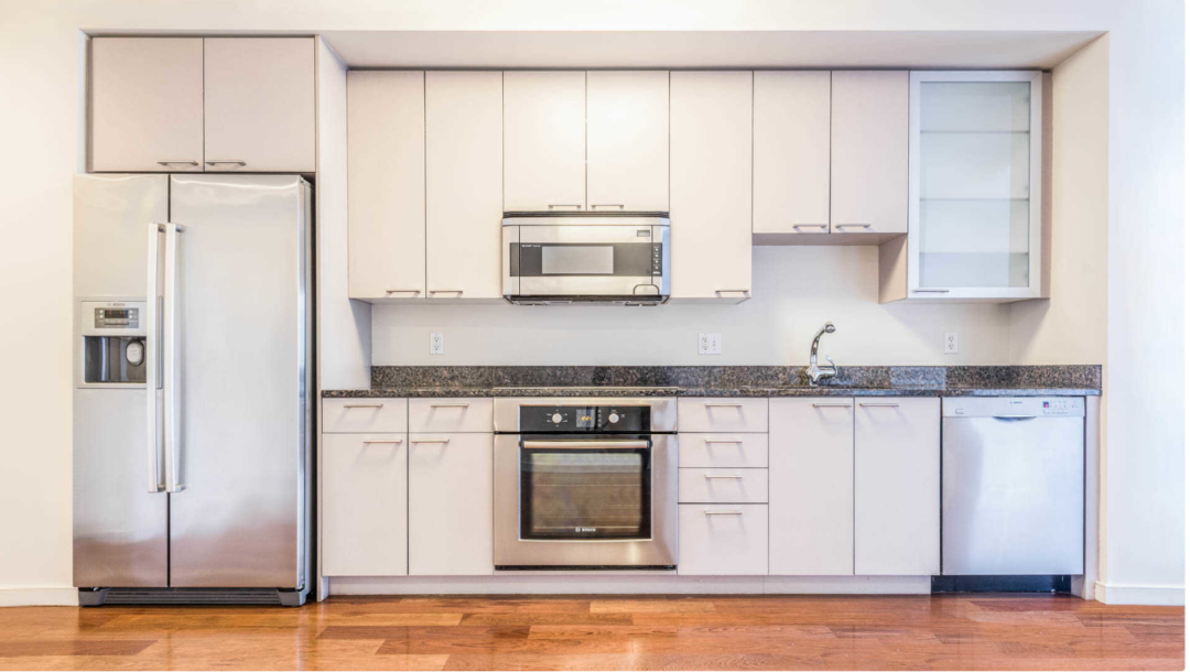 Modern kitchen with steel appliances, designer cabinetry and wood flooring