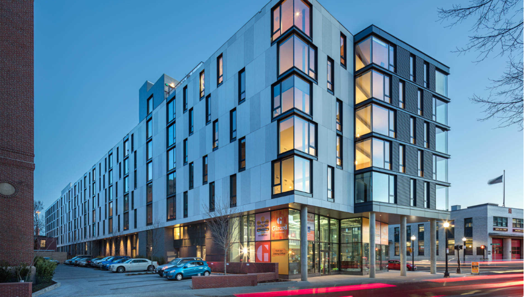 multi-story apartment building with commercial storefront on ground level