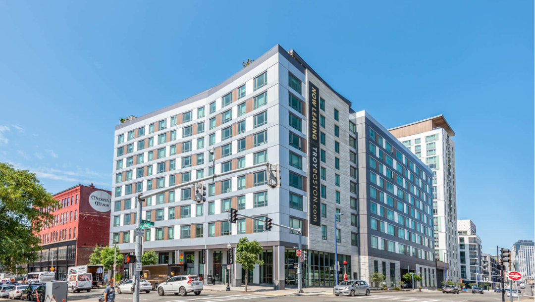 multi-story apartment building with commercial storefront on ground level