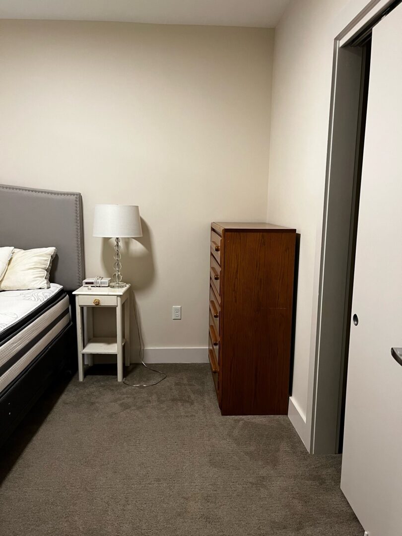 small beige bedroom with natural light and carpeting