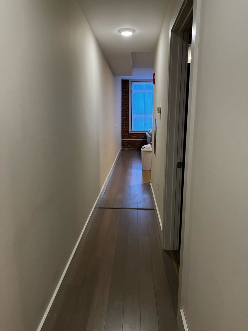 hallway with white walls and wood floors