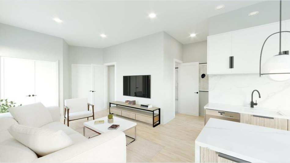 Open floor plan living room with white walls and hardwood floors