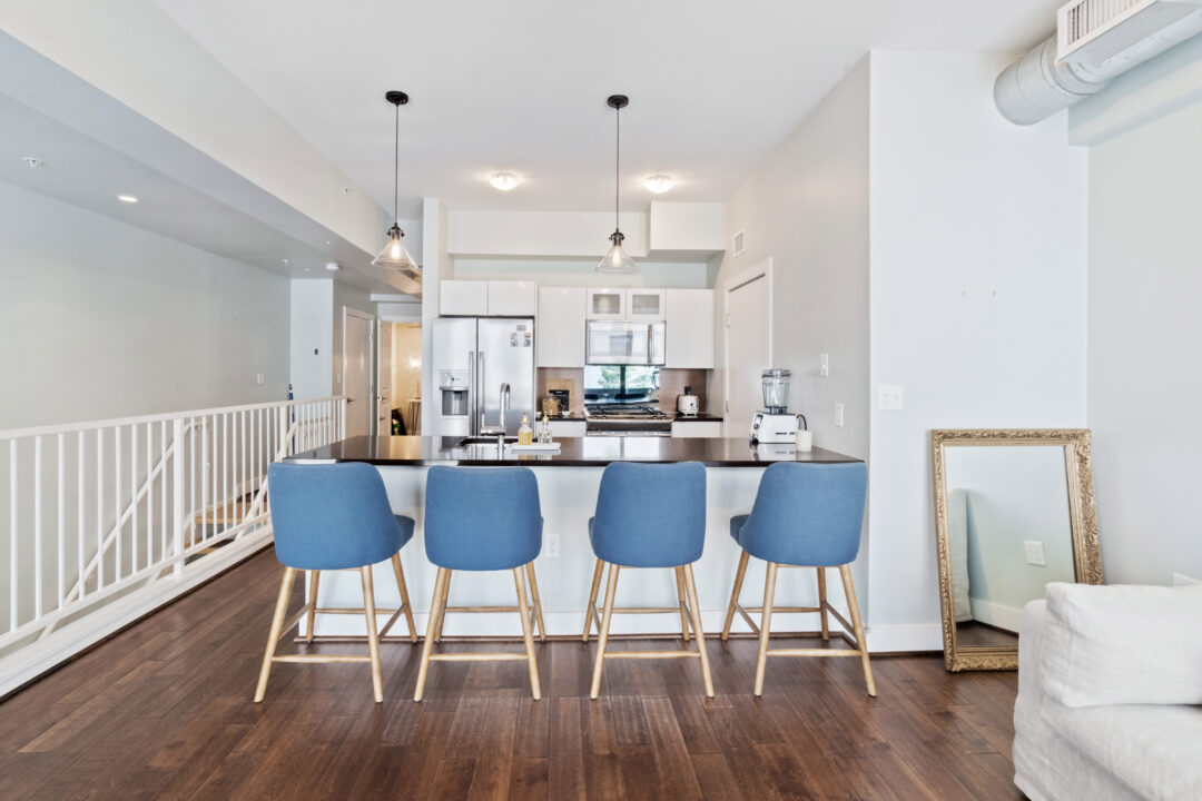 Modern kitchen with steel appliances, designer cabinetry and luxury plank flooring.