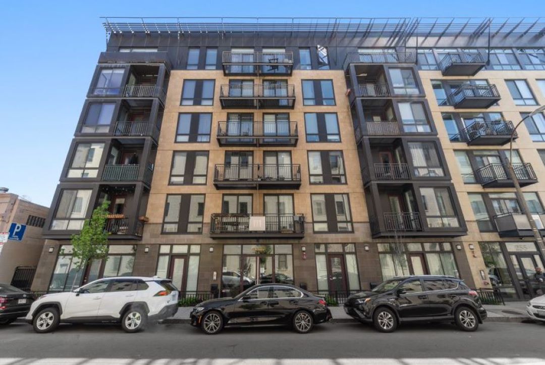 multi-story apartment building with commercial storefront on ground level