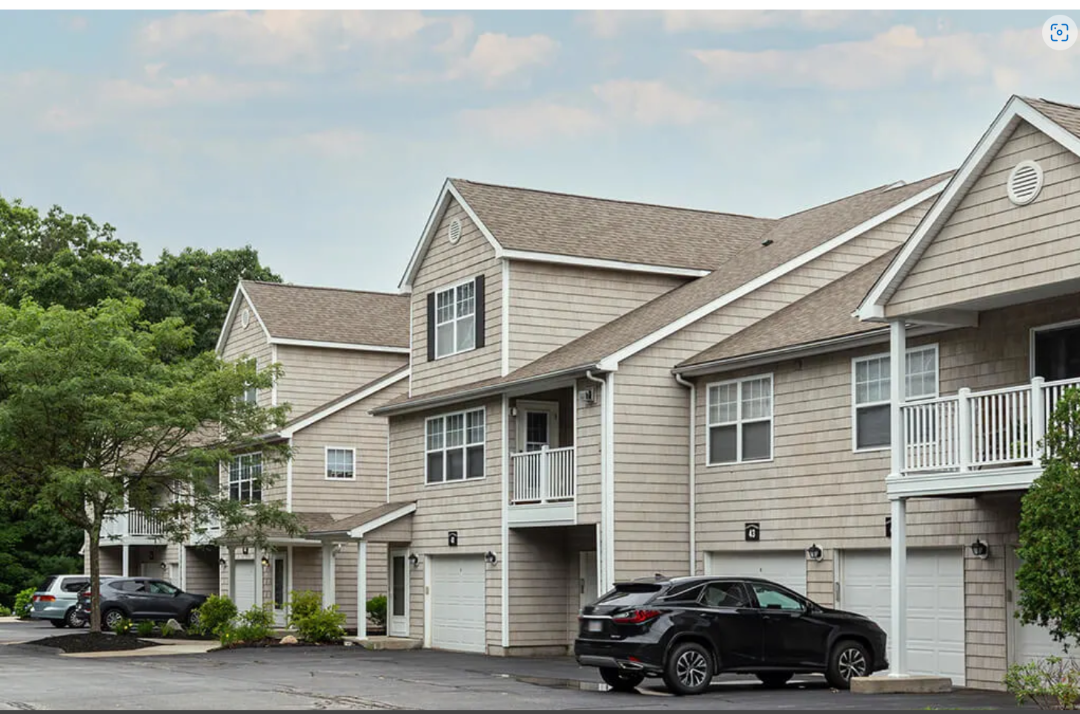 beige exterior condo style building with white railing balcony