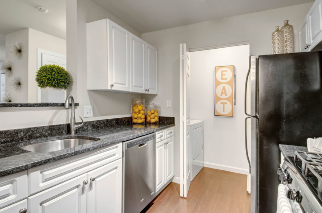 Modern kitchen with steel appliances, designer cabinetry and wood flooring.