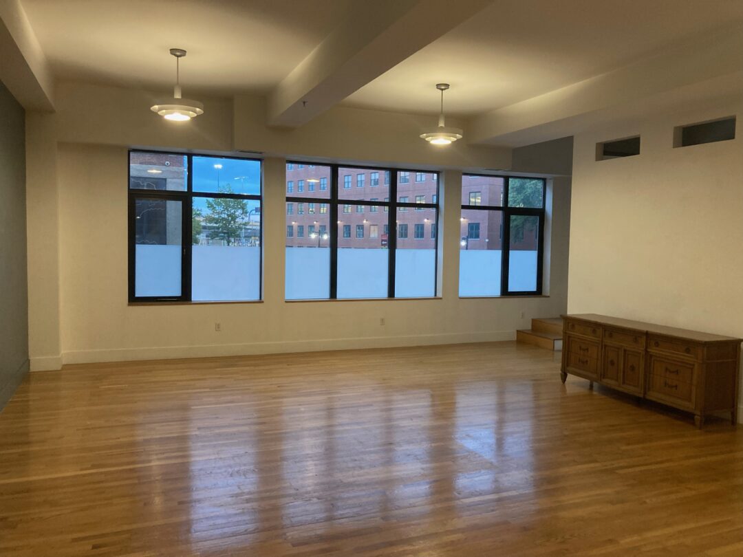 open layout living space with hard wood floors and large picture windows