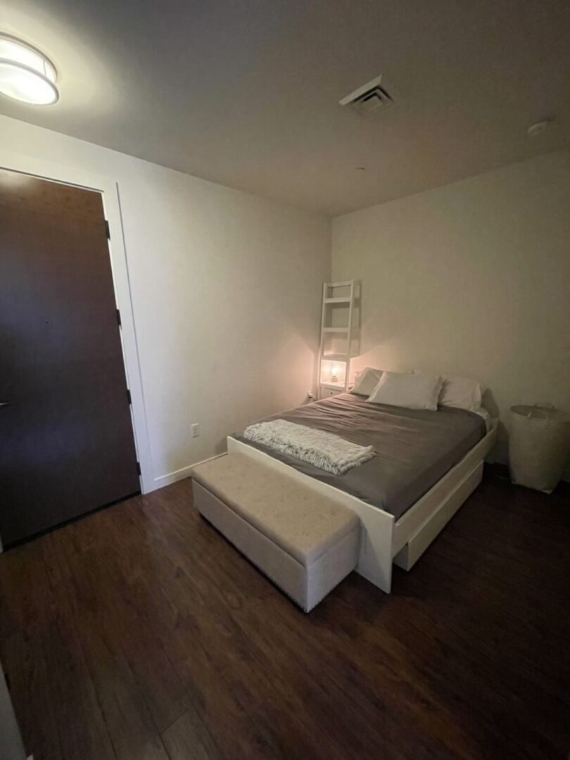 Small beige bedroom with hardwood floors