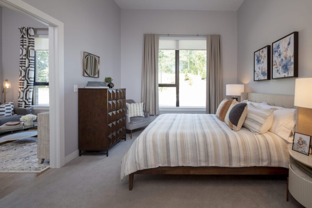 Small beige bedroom with carpeted floor and picture window