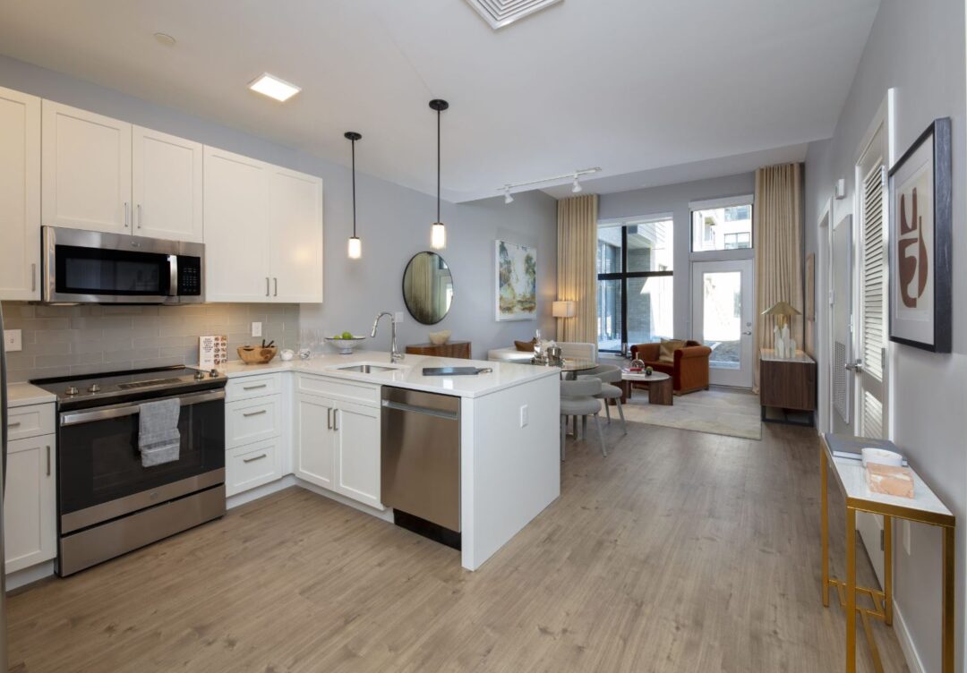 Modern kitchen with breakfast bar, custom cabinets, hardwood flooring open to living room