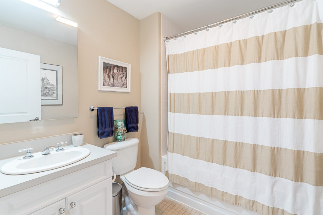 modern bathroom with beige walls, white vanity and a bathtub