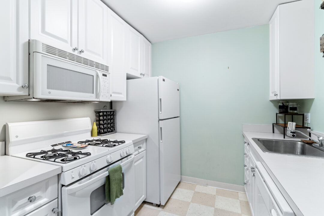updated kitchen with white appliances and tile floors