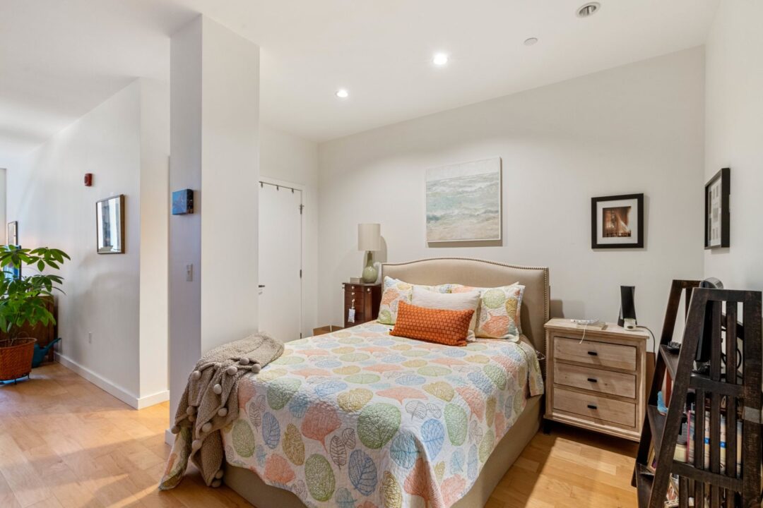 studio style bedroom area with white walls and wood floors