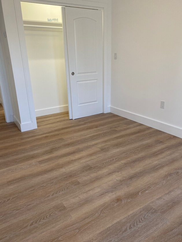 Bedroom with hardwood floors and closet